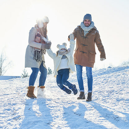 Familie beim Winterspaziergang im Schnee